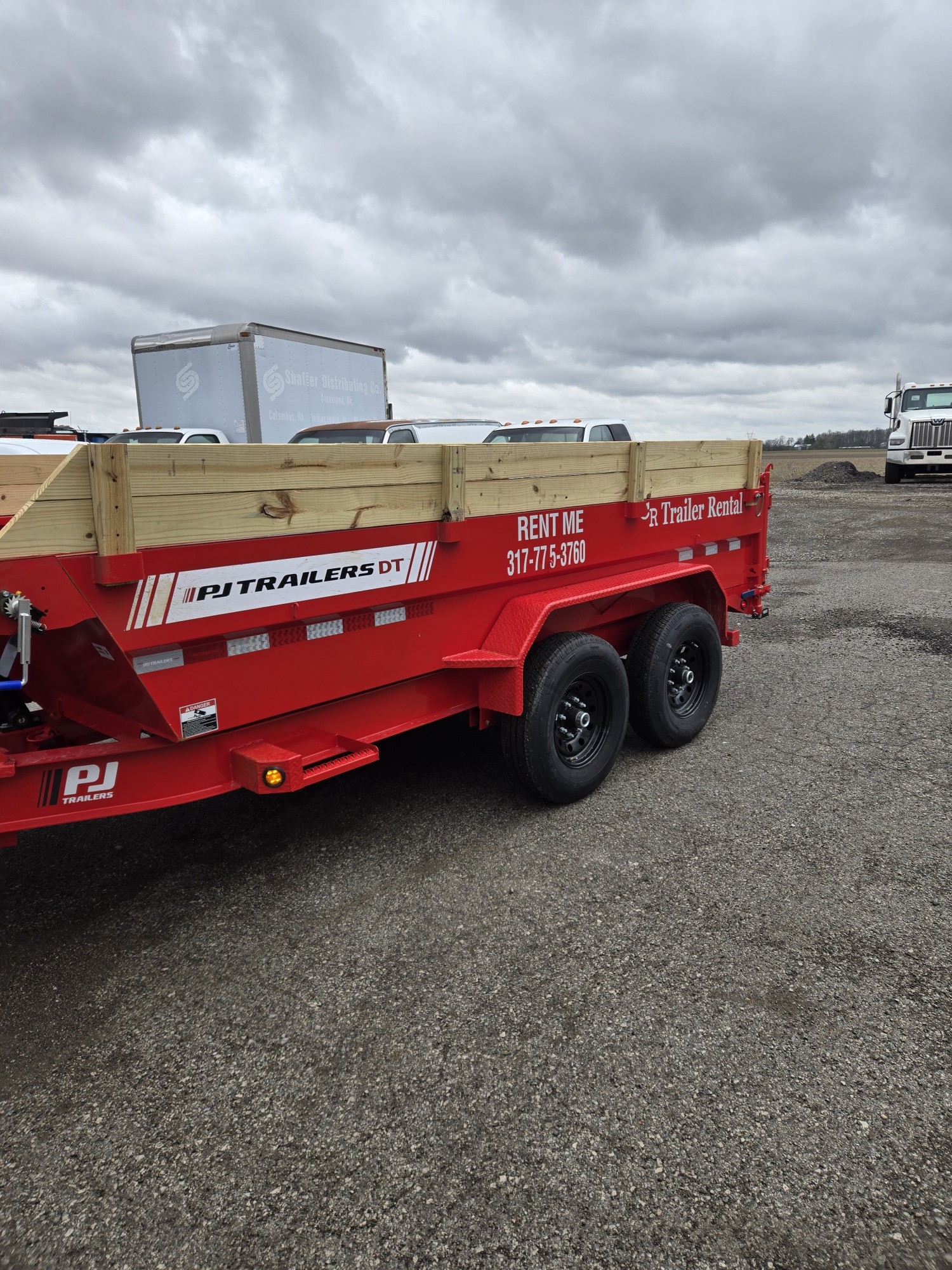 Red PJ Trailers DT 7x14 dump trailer side view with wood Monster Rails extensions for rent in Greenfield, IN